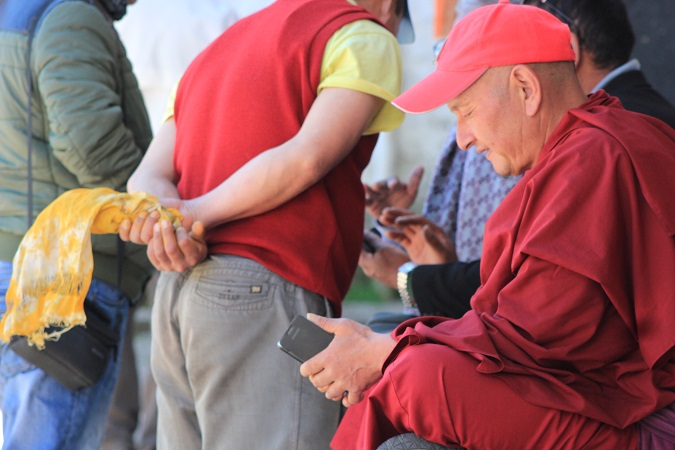 在达旺寺院僧侣在他们的智能手机